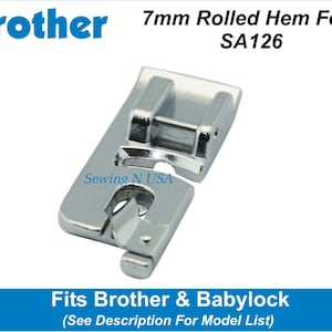 May include: A silver 7mm rolled hem foot for sewing machines. The foot is labeled "SA126" and is compatible with Brother and Babylock sewing machines. The text "Sewing N USA" is printed on the foot.
