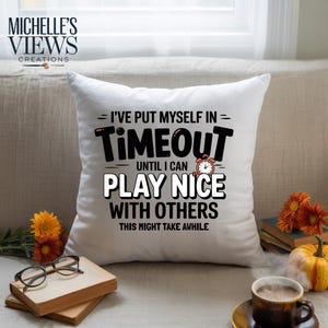 May include: White square throw pillow with the text "I'VE PUT MYSELF IN TIMEOUT UNTIL I CAN PLAY NICE WITH OTHERS THIS MIGHT TAKE AWHILE" in black and white. The pillow has a small alarm clock graphic.