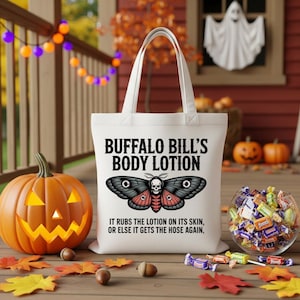 May include: A white tote bag with the text "BUFFALO BILL'S BODY LOTION" and a moth illustration. The bag also features the quote "IT RUBS THE LOTION ON ITS SKIN, OR ELSE IT GETS THE HOSE AGAIN." The image includes a carved pumpkin and candy.