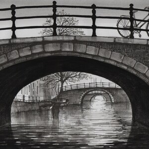 Puede incluir: Un dibujo en tinta negra y blanca de un puente de ladrillo sobre un canal. El puente tiene una barandilla y una bicicleta está aparcada en la parte superior del puente. El canal está tranquilo y refleja el cielo y el puente.