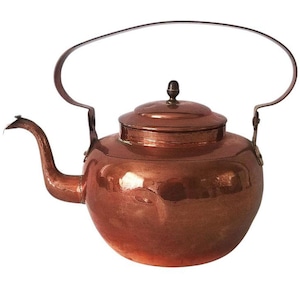 Op de afbeelding: Een koperen ketel met een glanzende, gehammerde afwerking en een gebogen handvat. De ketel heeft een deksel met een kleine knop bovenop.
