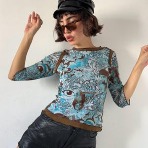Top vintage de malla azul y marrón Y2K, camisa ajustada con cuello barco y estampado gráfico transparente elástico para niños de club raver de los años 2000, regalo de ropa urbana retro.