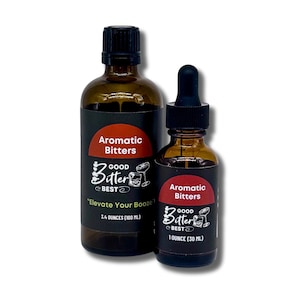 Puede incluir: Dos botellas de vidrio marrón de amargos aromáticos. La botella más grande tiene una etiqueta negra con el texto "Aromatic Bitters" y "Good Bitter Best". Dice "Elevate Your Booze!" y contiene 100 ml. La botella más pequeña contiene 30 ml.