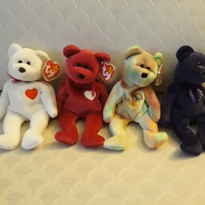 Puede incluir: Cuatro osos de peluche Beanie Baby de diferentes colores: blanco, rojo, tie-dye y morado. Cada oso tiene un corazón en el pecho y una etiqueta Ty adjunta.