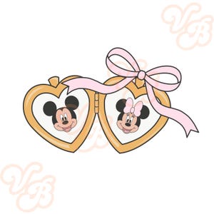 Op de afbeelding: Een gouden hartvormige locket met een roze lint. De locket is open en laat foto's van Mickey Mouse en Minnie Mouse zien.