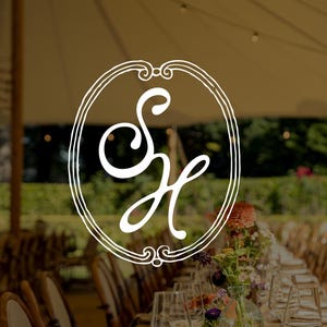 May include: A white line art logo featuring the stylised letters SH enclosed within an oval frame, superimposed over a blurred outdoor event setting with a long dining table, floral centrepieces, and a large canopy tent structure.