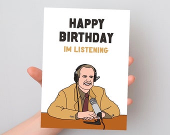 May include: A white greeting card featuring the text HAPPY BIRTHDAY IM LISTENING in black and gold. The illustration depicts a person wearing a tan blazer, a dark tie, and black headphones, sitting at a brown desk with a silver microphone in front.