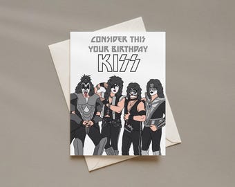 May include: A white greeting card featuring a graphic illustration of the rock band KISS in their signature black and white stage makeup and costumes. The text at the top reads, "CONSIDER THIS YOUR BIRTHDAY KISS" in a bold, stylized font.