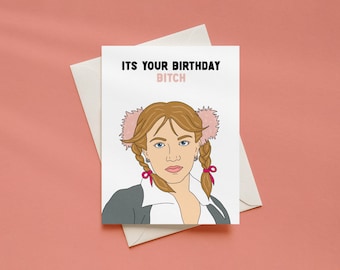 May include: A white greeting card featuring a cartoon illustration of a person with brown hair in pigtails, wearing a grey blazer over a white shirt. The text reads ITS YOUR BIRTHDAY BITCH in black and pink lettering. A white envelope is included.