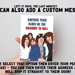 May include: A rectangular greeting card featuring a cartoon illustration of a rock band with five members. The text reads: ANOTHER YEAR OLDER ON THE HIGHWAY TO HELL. The central figure wears a blue blazer and white horns. The background is white.