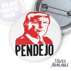 May include: White button with a red image of a person's face and the word "PENDEJO" in black. The text "3 SIZES AVAILABLE" is in blue script. The words "BLUE WAVE INK" are in a blue circle.