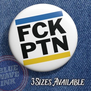 May include: White button with the text "FCK PTN" in bold black letters. The button has a blue and yellow stripe design. The text "3 SIZES AVAILABLE" is written in cursive below the button.
