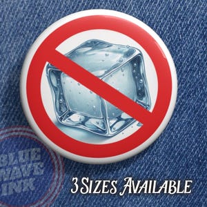 May include: A round button with a red prohibition symbol over a detailed illustration of an ice cube. The button has the text "3 SIZES AVAILABLE" in a cursive font. The button is on a blue denim background.
