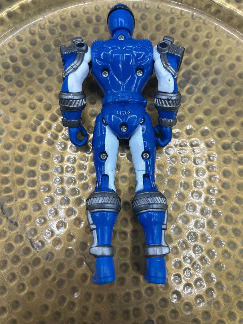 K&ouml;nnte beinhalten: Eine blaue Actionfigur mit wei&szlig;en und silbernen Akzenten. Die Figur hat einen Helm, r&uuml;stungs&auml;hnliche Details und bewegliche Gelenke. Die Nummer "41708" ist auf der R&uuml;ckseite der Figur aufgedruckt. Das Spielzeug ist aus Kunststoff.