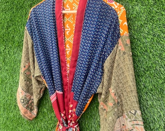 May include: A patchwork kimono robe with a mix of blue, green, red, and orange fabrics. The robe has a long sleeve and a tie belt.