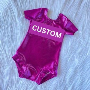Short Sleeves Glitter Metallic Magenta round neck baby girl bodysuit/Leotard with White Custom glitter Logo Detail. Ballerina bodysuit