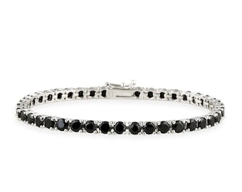 May include: A silver bracelet with a row of black gemstones. The bracelet has a clasp closure and is set against a white background. The gemstones are round and evenly spaced.