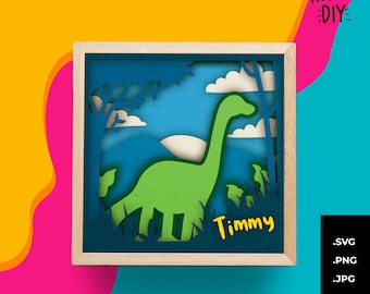 Pode incluir: Uma obra de arte em papel em camadas emoldurada com um dinossauro Brontosaurus verde em uma paisagem com árvores, nuvens e um céu azul. O nome "Timmy" está escrito em amarelo. A moldura é marrom claro.