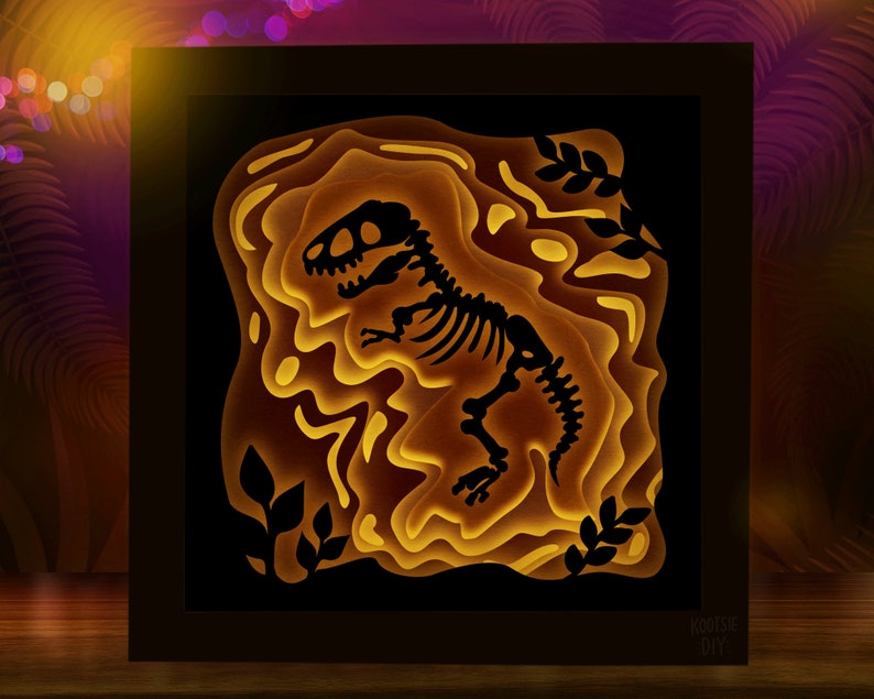 Pode incluir: Uma moldura de madeira preta com um design de arte em papel 3D em camadas de um esqueleto de dinossauro. O dinossauro &eacute; iluminado por tr&aacute;s, criando um efeito brilhante. O fundo &eacute; marrom escuro com um padr&atilde;o texturizado.