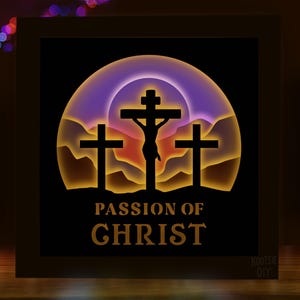Puede incluir: Una caja de sombra de madera con una silueta de Jesús en la cruz sobre un fondo de puesta de sol. El texto "Passion of Christ" está impreso debajo de la imagen.