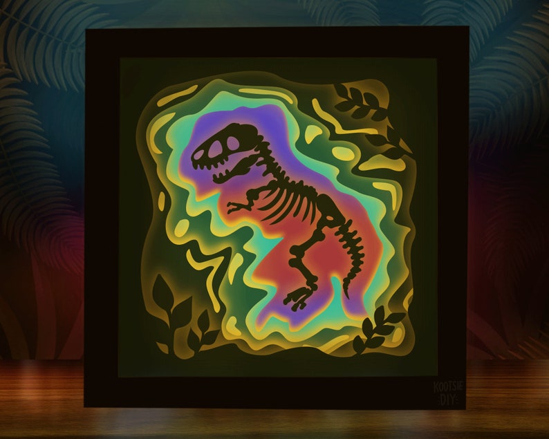 Pode incluir: Uma pe&ccedil;a de arte em papel 3D emoldurada que retrata um esqueleto de dinossauro em um fundo colorido e em camadas. O dinossauro &eacute; um T-Rex com uma silhueta preta e ossos brancos. O fundo &eacute; uma mistura vibrante de verde, azul, roxo e amarelo.