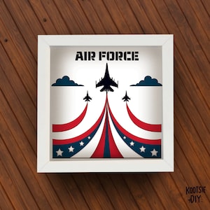 May include: A white frame with a red, white, and blue American flag design and the words "AIR FORCE" in black. Three black silhouettes of fighter jets fly in formation.
