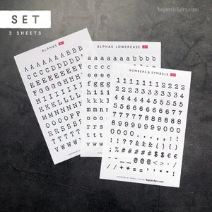 May include: Three sheets of sticker paper with alphabet letters, lowercase letters, numbers, and symbols. The stickers are black on white paper.