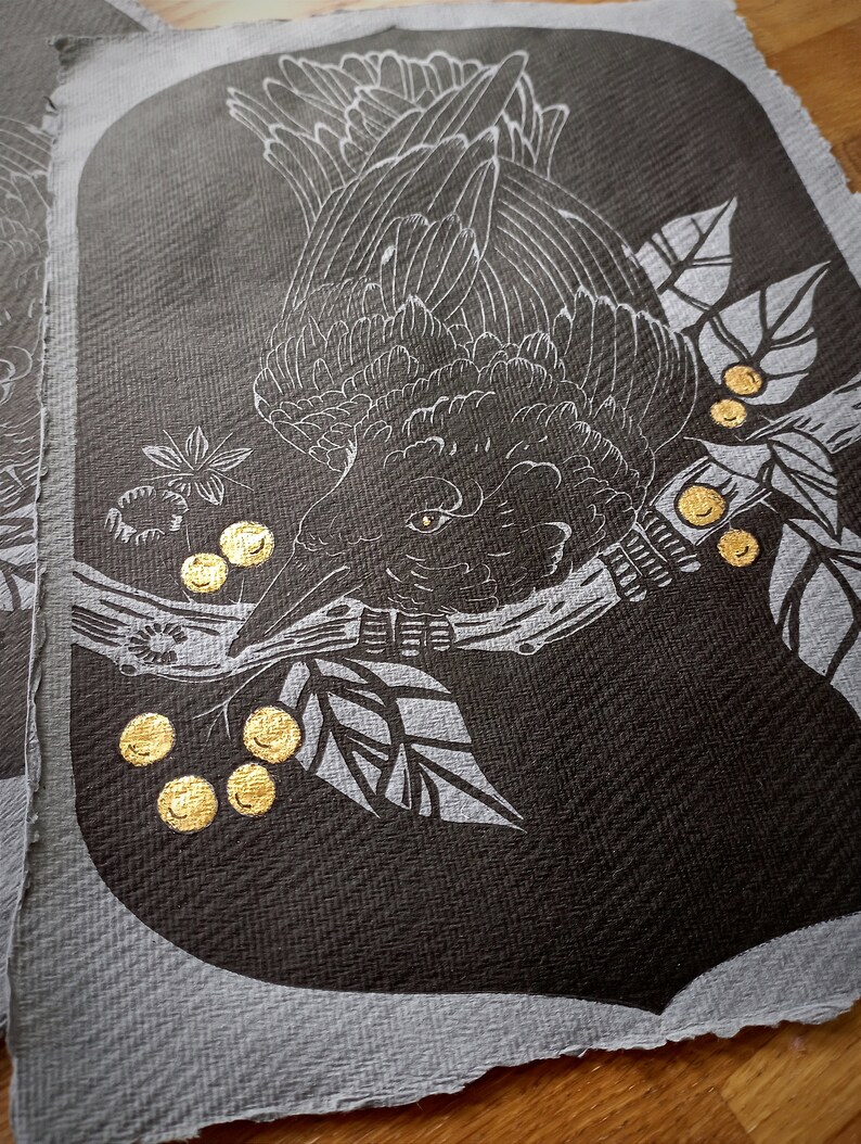 May include: A dark gray fabric panel featuring a detailed white illustration of a bird perched on a branch with leaves and golden berries. The bird's feathers and eye are intricately drawn. The panel has a textured appearance.