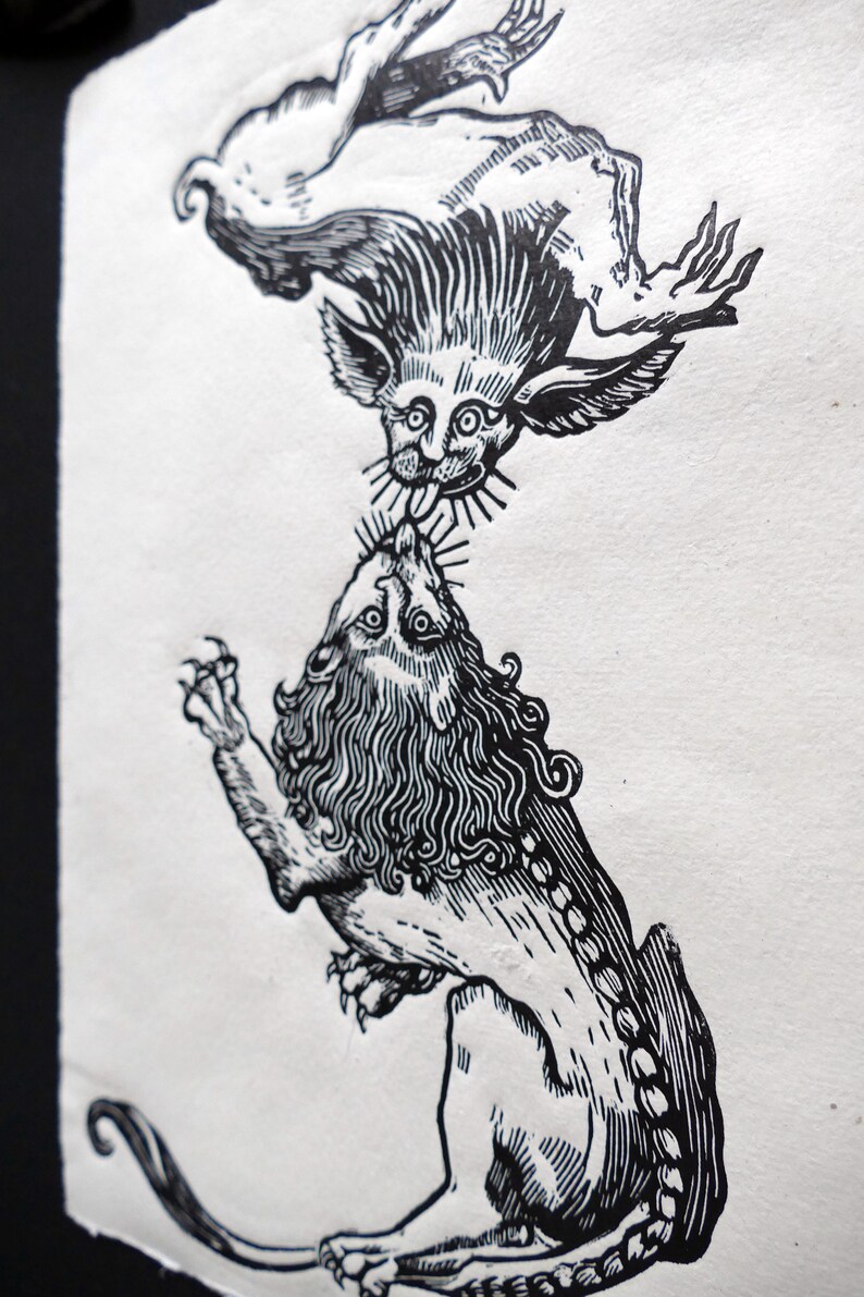 May include: Black and white woodcut print of a lion and a winged creature. The lion is on the bottom and the winged creature is on top. The winged creature is biting the lion's neck.