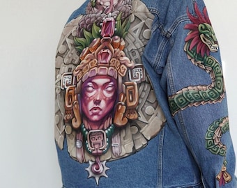 May include: A denim jacket with a hand-painted design featuring a Mayan-inspired figure with a jeweled headdress and a serpent on the sleeve.