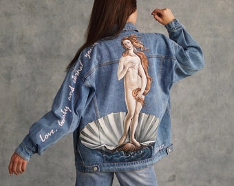 May include: A blue denim jacket with a painting of the Birth of Venus on the back. The jacket has the words "love, beauty and eternal youth" written on the left sleeve.