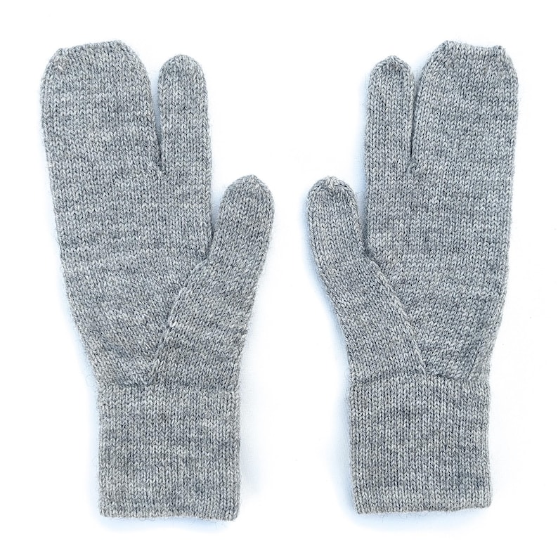 May include: A pair of gray knit gloves with a split-toe design. The gloves are made of a textured, heathered yarn and feature a ribbed cuff. The thumb is separated from the other fingers.