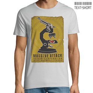 Puede incluir: Una camiseta blanca con un diseño de póster de estilo vintage que presenta un microscopio con un corazón en la lente y una pistola en el fondo. El texto en el póster dice "Massive Attack Thievery Corporation Friday November Fifth 2010 Santa Barbara Bowl Santa Barbara California".