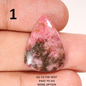 Pode incluir: Uma pedra preciosa triangular polida com um padrão mosqueado rosa e castanho. A pedra é segurada em uma mão e rotulada com o número "1". O texto "GO TO THE NEXT PAGE TO SEE MORE OPTION" é visível na parte inferior.
