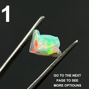 May include: A small, iridescent opal gemstone held by metal tweezers. The opal displays a vibrant array of colors, including red, green, and yellow. The number "1" is in the upper left corner, and text at the bottom reads "GO TO THE NEXT PAGE TO SEE MORE OPTIOUNS."