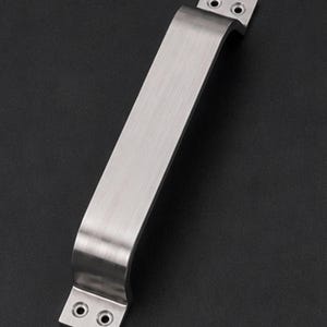 May include: A brushed silver metal door handle with a rectangular grip and two flat mounting plates at each end. Each mounting plate features two circular screw holes for installation, providing a secure attachment point for doors or cabinets.