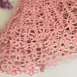 Puede incluir: Un encaje de ganchillo rosa con un delicado patr&oacute;n floral.