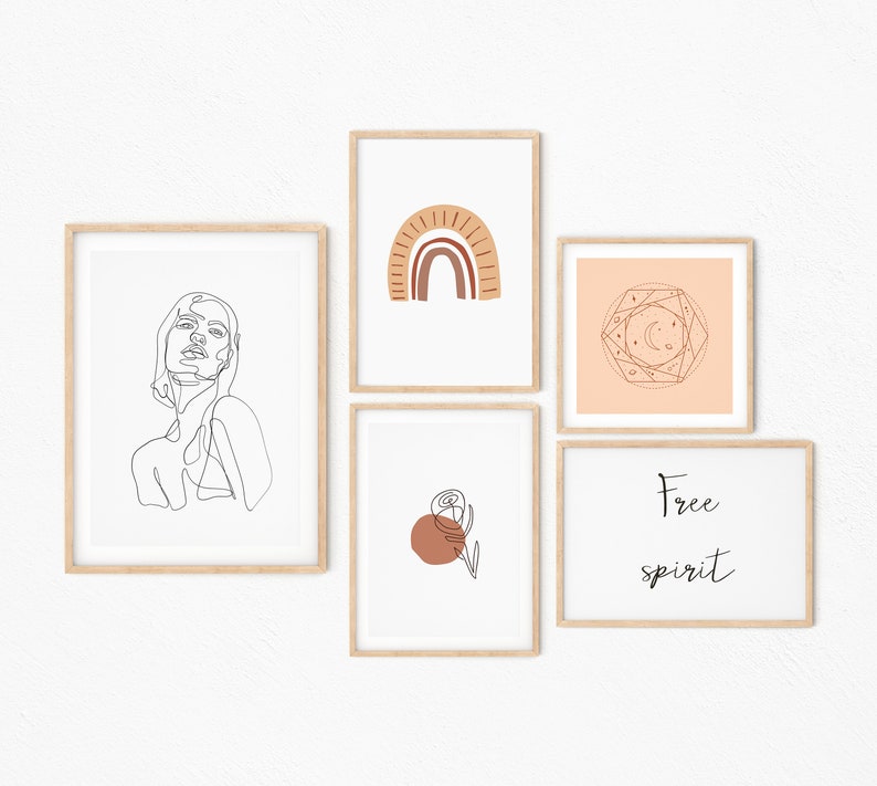 May include: Five framed prints with minimalist line art designs. The prints feature a woman's face, a rainbow arch, a geometric design with stars and moons, a single flower with a red circle, and the text "Free spirit".