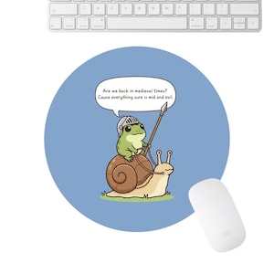 May include: A white ceramic mug with a black handle and the text "But First, Coffee" in a black, bold font. The mug is on a white surface.