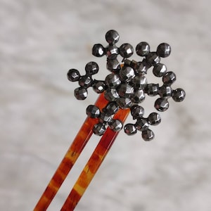 Antique cut steel snowflake hair ornament.