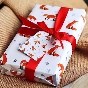Carta da regalo a tema natalizio con volpi. Illustrazione originale dell'acquerello. Confezione regalo originale. Idea regalo di Natale.