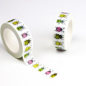 Puede incluir: Dos rollos de cinta adhesiva decorativa con un patrón repetido de escarabajos coloridos. Los escarabajos son en tonos de verde, amarillo, rosa y negro. Un rollo está parcialmente desenrollado.
