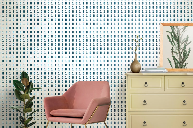 May include: A pink velvet armchair with gold metal legs sits in front of a white wall with a blue and white binary code pattern wallpaper. A dresser with three drawers and a vase with a dried plant are on the right side of the image.