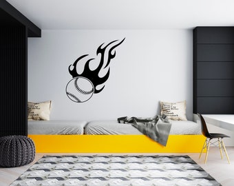 May include: A black and white baseball with flames behind it is on a white wall. The baseball is on a yellow bed frame with a gray blanket and a white pillow with black text.