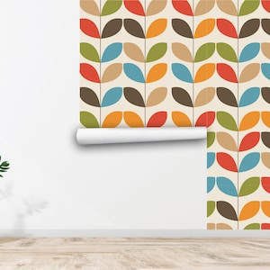 May include: A roll of wallpaper with a repeating pattern of stylised leaves in shades of brown, green, orange, red, and blue on a cream background.
