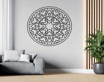 May include: A black and white mandala wall decal with a geometric design featuring hearts and crowns. The decal is applied to a white wall in a living room setting.