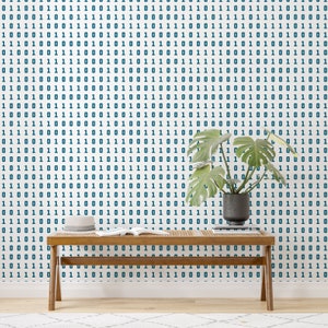 May include: A wooden bench with a book on top sits in front of a white wall with a blue and white binary code pattern. A potted plant with green leaves is on the right side of the bench.
