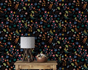 May include: A black background with a repeating pattern of colorful flowers and leaves. A table with a wooden top and legs is in the foreground. A lamp with a white and gray chevron patterned shade sits on the table. A wooden bowl with a starfish and other decorative items sits on the table.