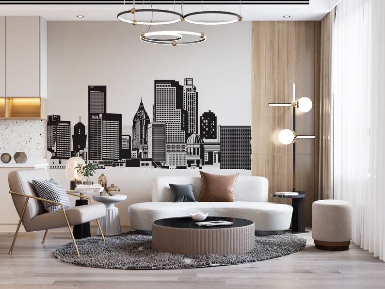 May include: A modern living room with a white sofa, a black and white rug, a coffee table, and a grey armchair. The wall behind the sofa features a black and white cityscape decal.