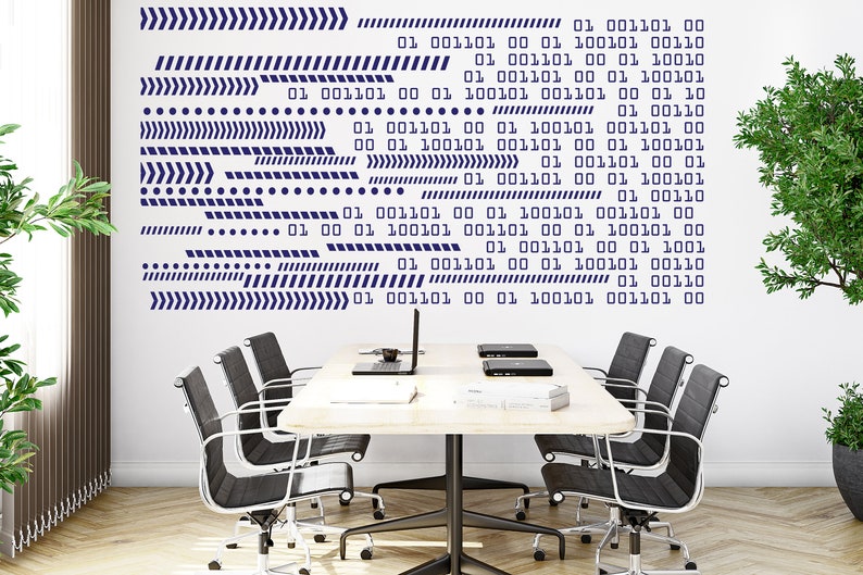 Op de afbeelding: Een witte muur met een blauw en wit binair codepatroon. De muur bevindt zich in een moderne kantooromgeving met een tafel en vier stoelen.